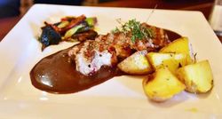 Teller mit Schweinemedaillons, Kartoffeln und Gemüse