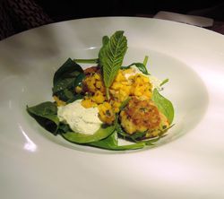 Teller mit Fischcookies auf Mangosalsa mit Minz-Schmand und Spinatsalat