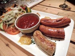 Teller mit Bratwurst, Ketchup und Salat